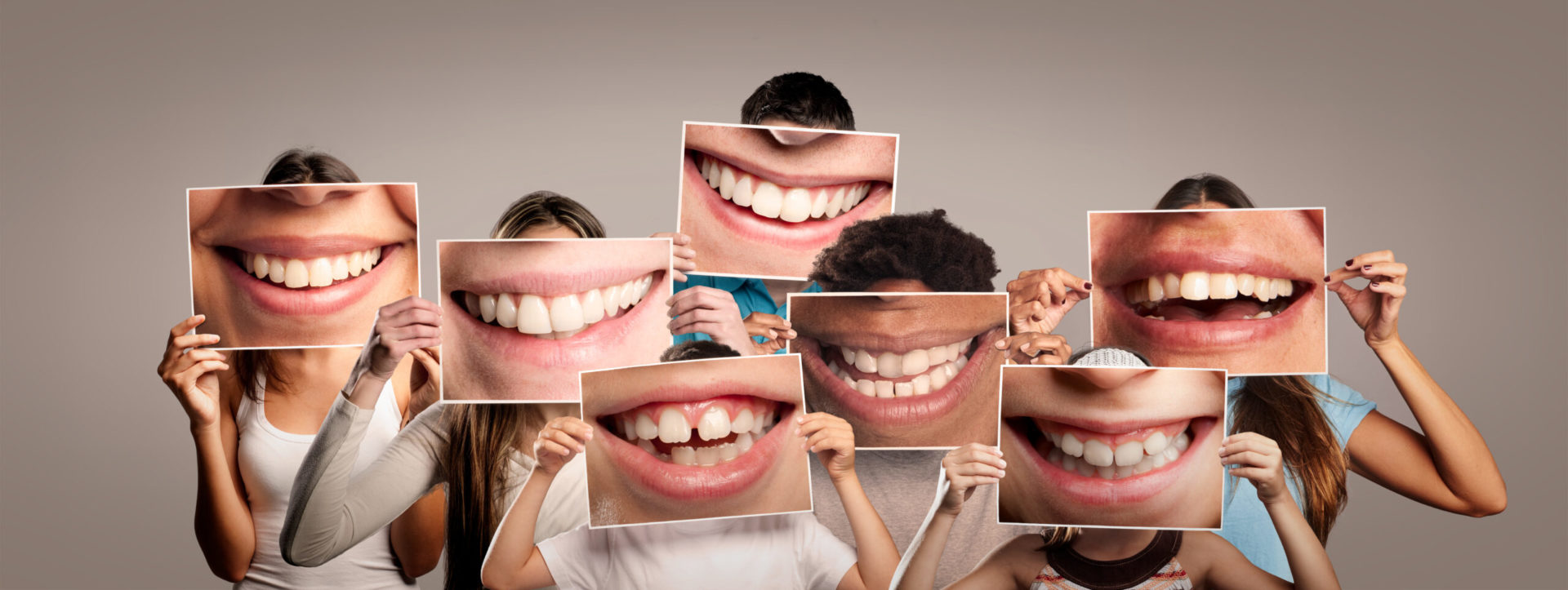 group of happy people holding a picture of a mouth smiling on a piece of paper