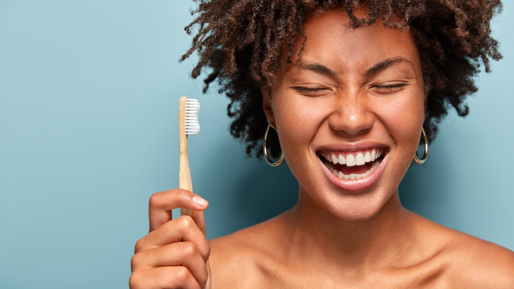 Woman smiling holding a toothbrush 
